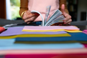 Sophie parcours un livre sur fond des étoffes de tissus