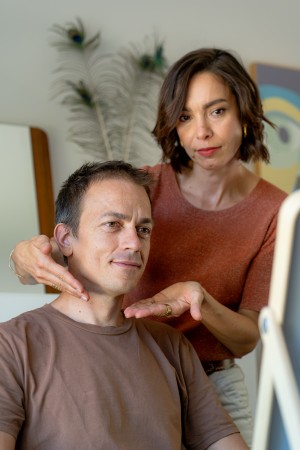 Sophie montre la forme du visage à son client masculin