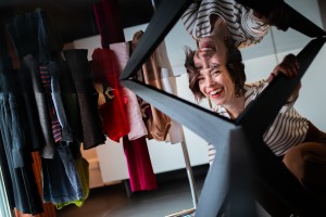 Femme souriante avec vêtements en arrière plan